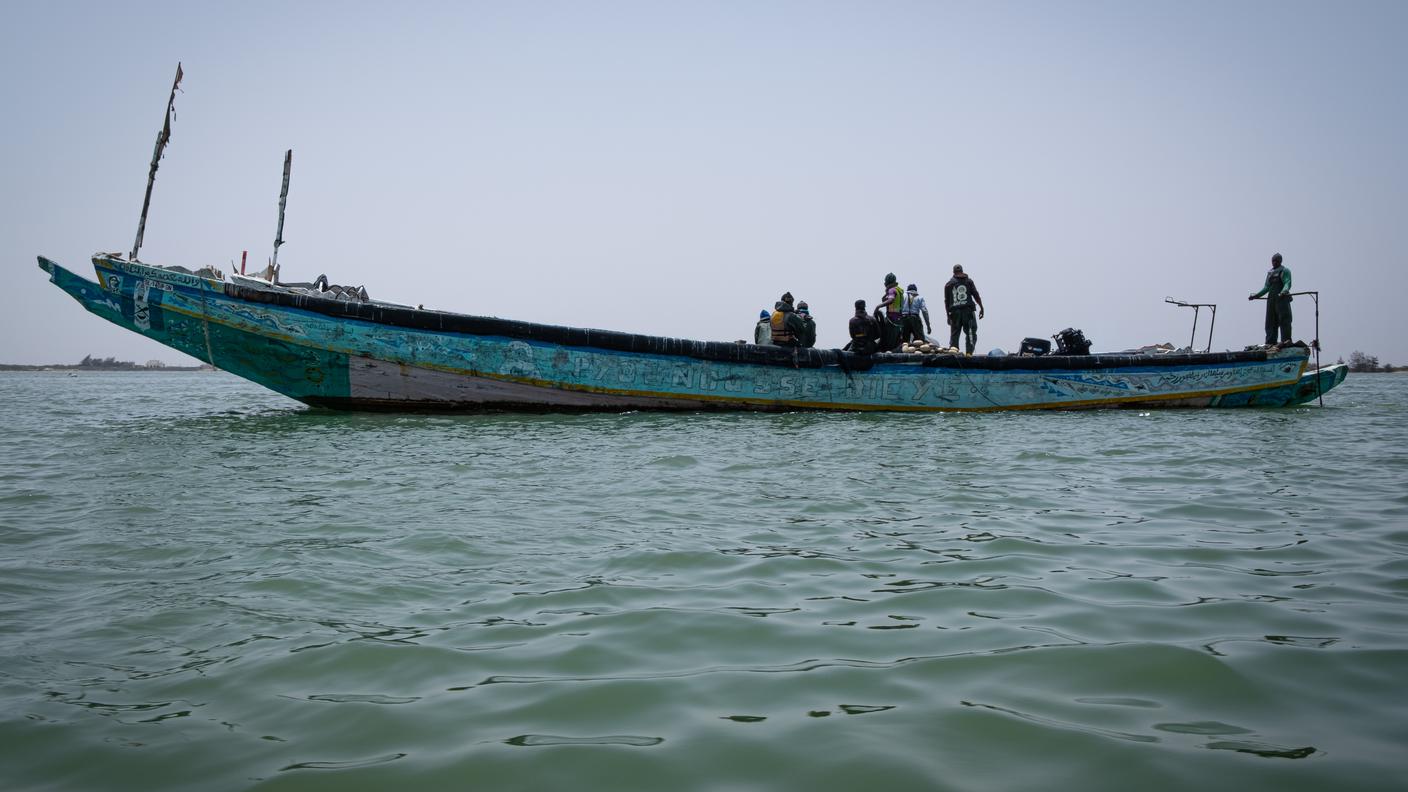 Una piroga di pescatori si dirige al largo delle coste di Saint Louis, uno dei principali centri di partenza dei migranti del Senegal, diretti verso le isole Canarie