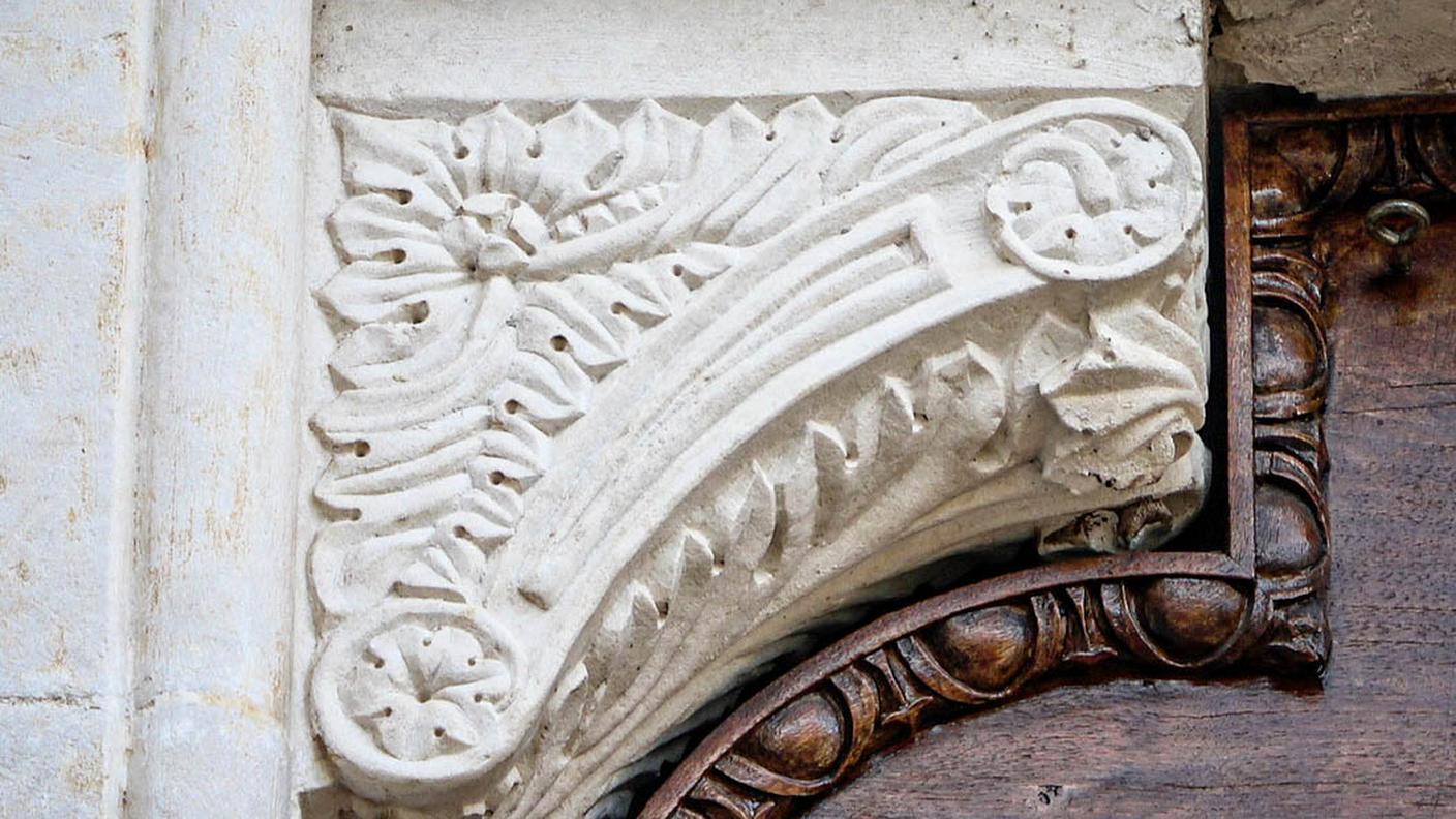 Particolare del portale della chiesa di San Pietro a Torano, raffigurante la rosa comacina, scolpita da Martino de Biasca e simbolo dei maestri comacini