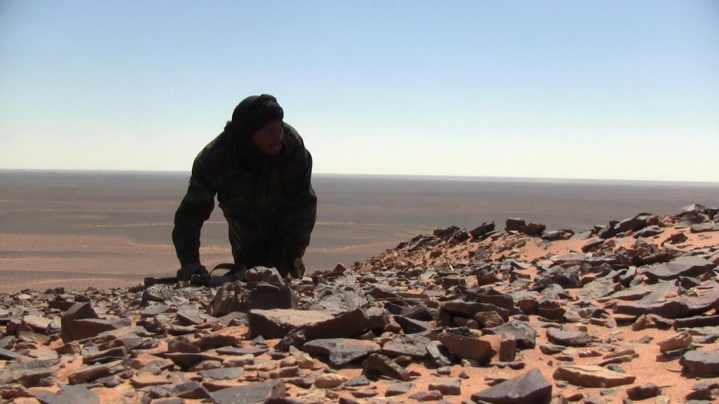 Un combattente saharawi si arrampica su una collina nell'area di Mahbes