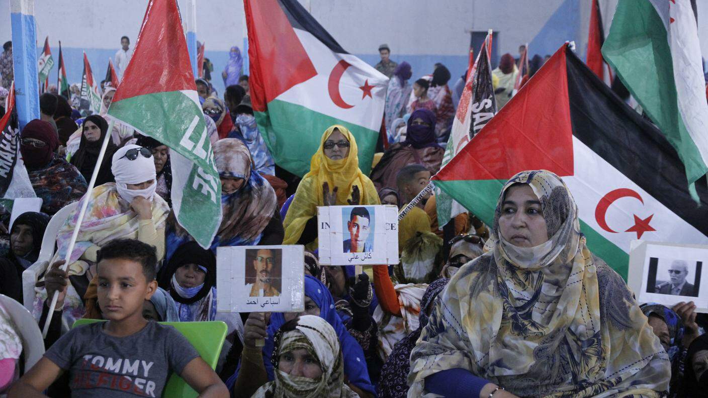 Donne saharawi mostrano le immagini dei mediattivisti detenuti nel Sahara Occidentale occupato