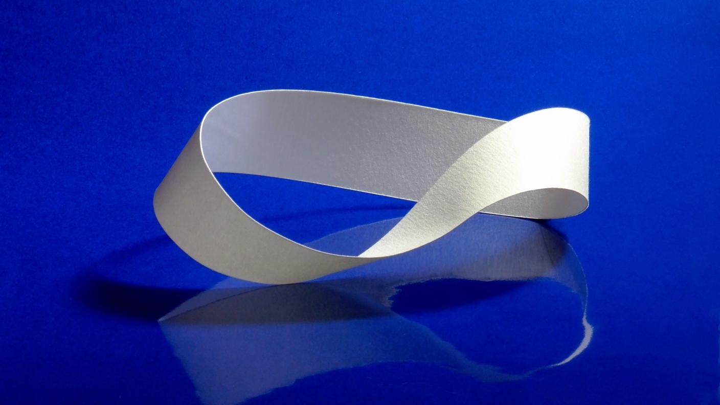 Un nastro di Möbius, una superficie continua che ha solamente un  lato e uno spigolo: non è possibile definire due facce diverse come per un normale foglio di carta.