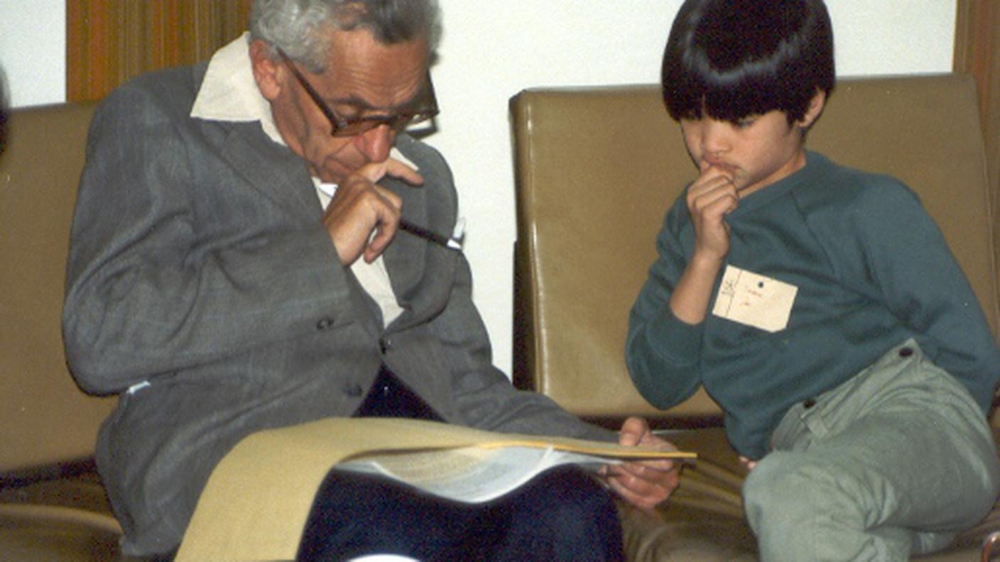 I matematici Paul Erdős (a sinistra) e Terence Tao (a destra) nel 1985 all'Università di Adelaide (Australia). Paul Erdős  era già un matematico affermato, mentre Terence Tao era un bambino prodigio. All'età di 24 anni Terence Tao, australiano e americano, divenne professore all'Università della California di Los Angeles (Stati Uniti), dove lavora tutt'ora.  A soli 31 anni ricevette la Medaglia Fields, il "Nobel della matematica". Paul Erdős , ungherese, è invece considerato uno dei matematici più prolifici del Ventesimo secolo.