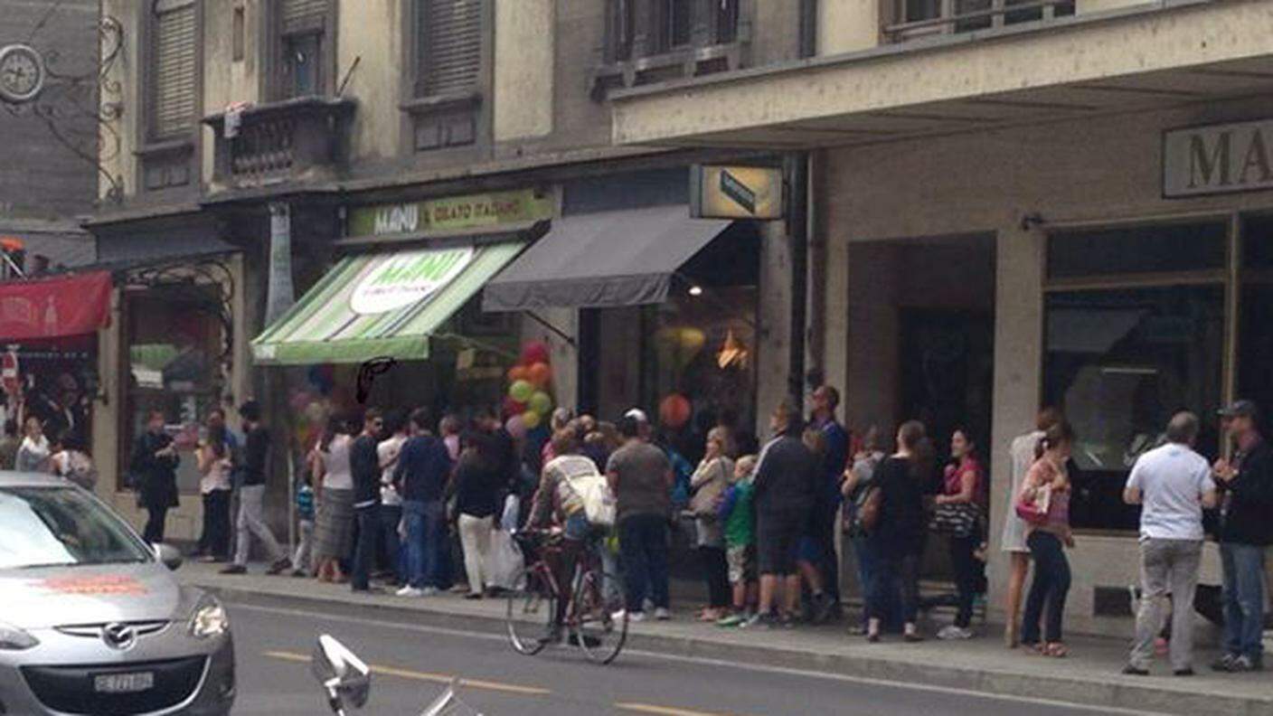 Clienti in coda davanti alla gelateria del campione svizzero in una giornata estiva