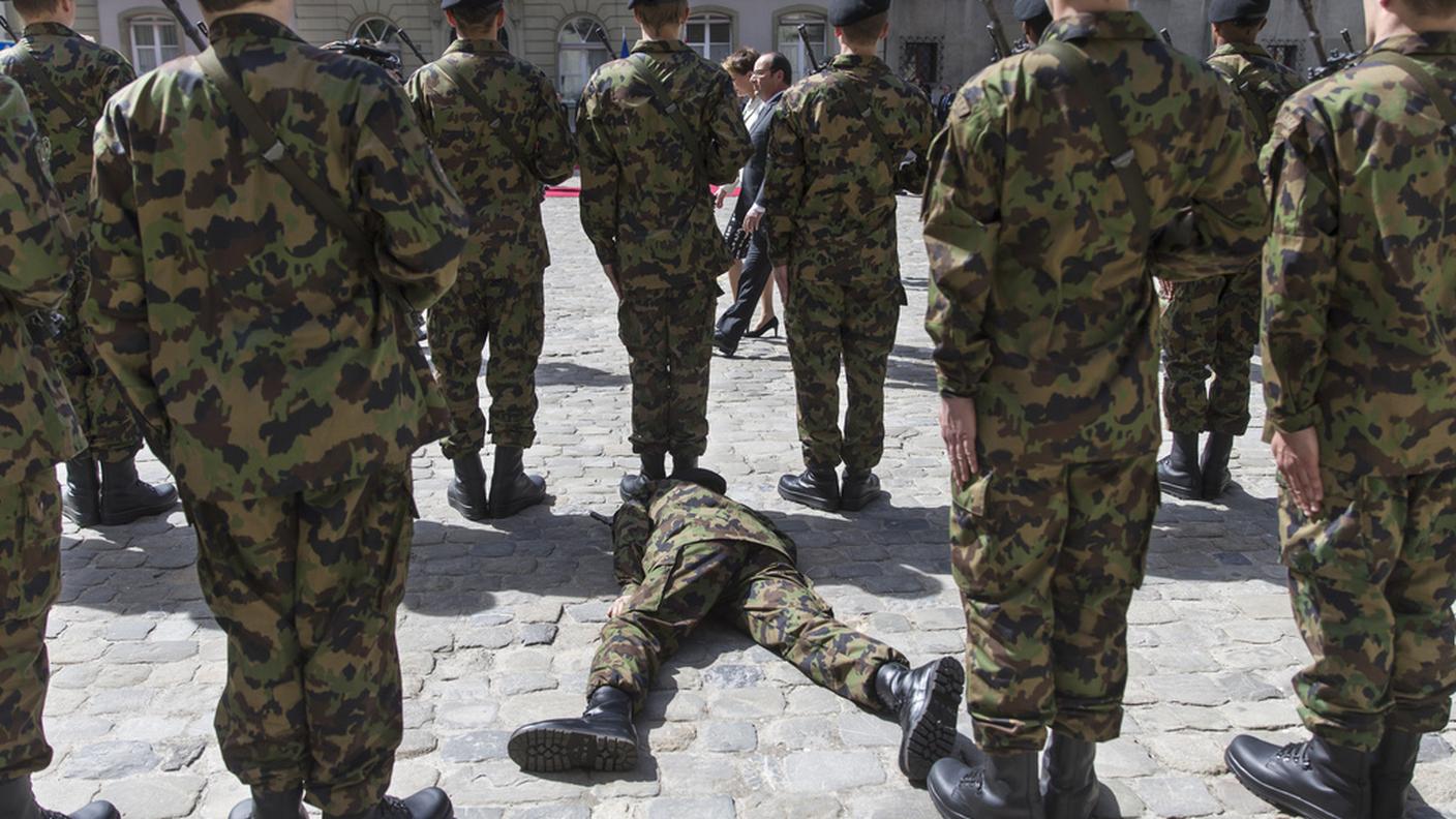 Un soldato svenuto durante il passaggio di Hollande davanti alle truppe
