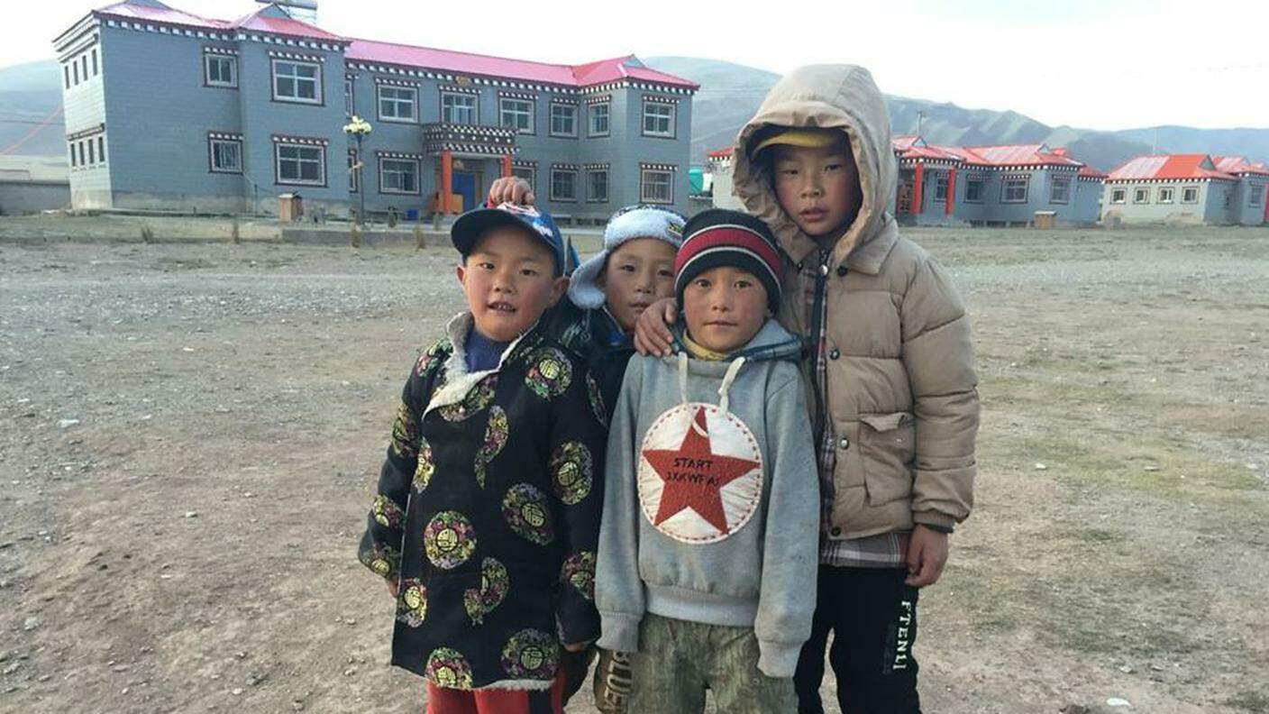 Bambini nel cortile della struttura Tadra a Dawu, provincia Qinghai, Cina