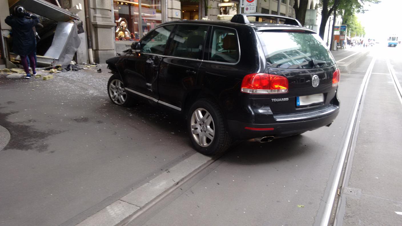 L'auto con targhe tedesche utilizzata per sfondare la vetrina. Sullo sfondo due dei quattro malviventi