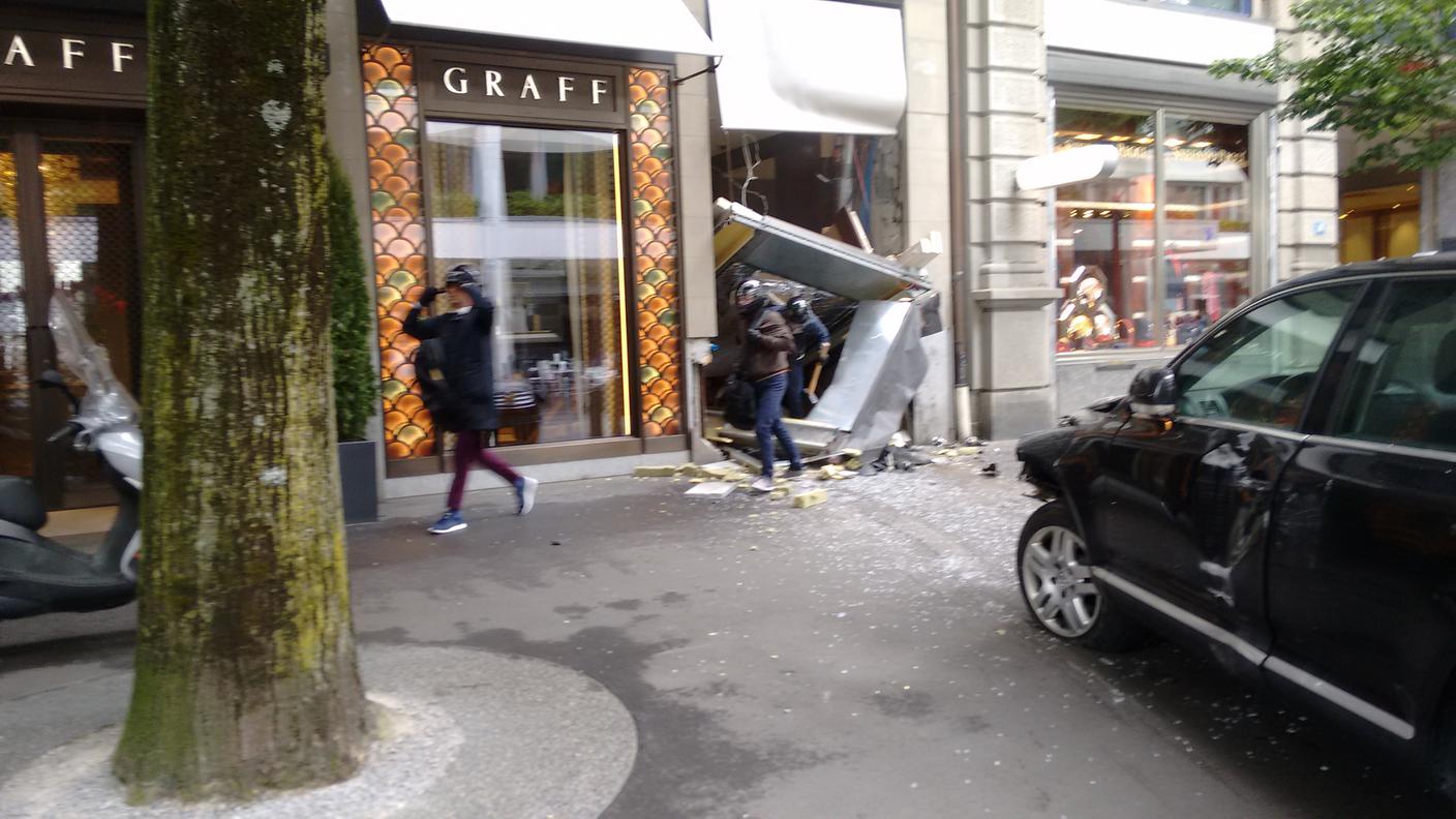 I ladri mentre lasciano il negozio. Due di loro fuggiranno a piedi