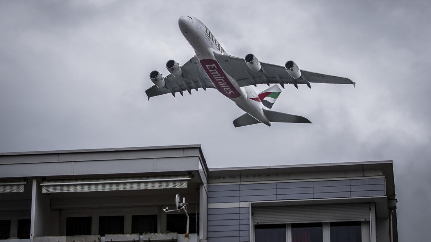 Un A380 di Emirates che sorvola i tetti zurighesi
