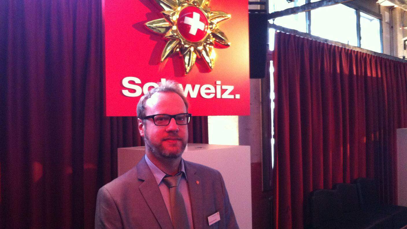 André Aschwanden, qui davanti all'attuale logo di Svizzera Turismo