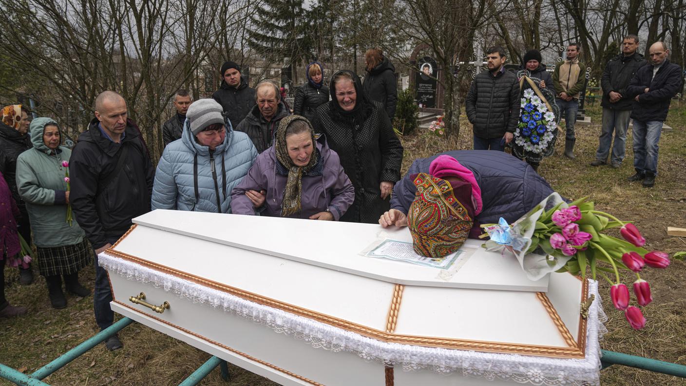 La mamma della dodicenne Veronika Kuts piange sulla bara della bimba uccisa da ordigni russi