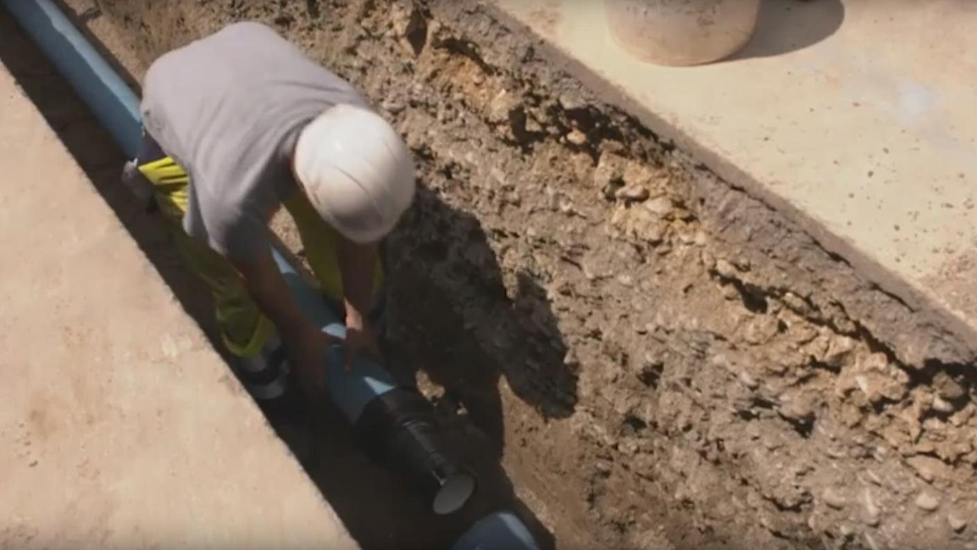 Un operaio impegnato nella posa di una condotta. A canalizzazioni vecchie e corrose si devono perdite anche ingenti di acqua potabile