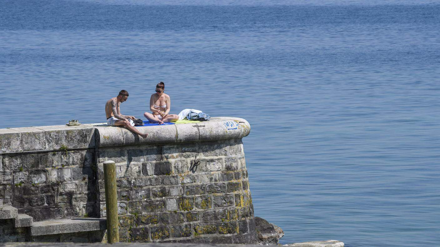 Una coppia si gode il sole in riva al lago Lemano