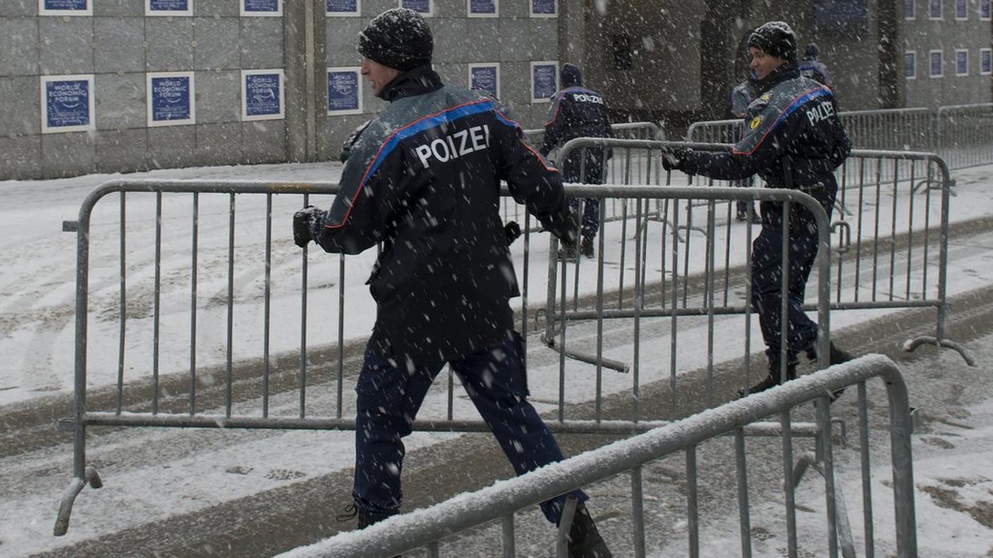 WEF Swiss Police officers carry security barriers under the snow outside the Congress Center, ky.JPG