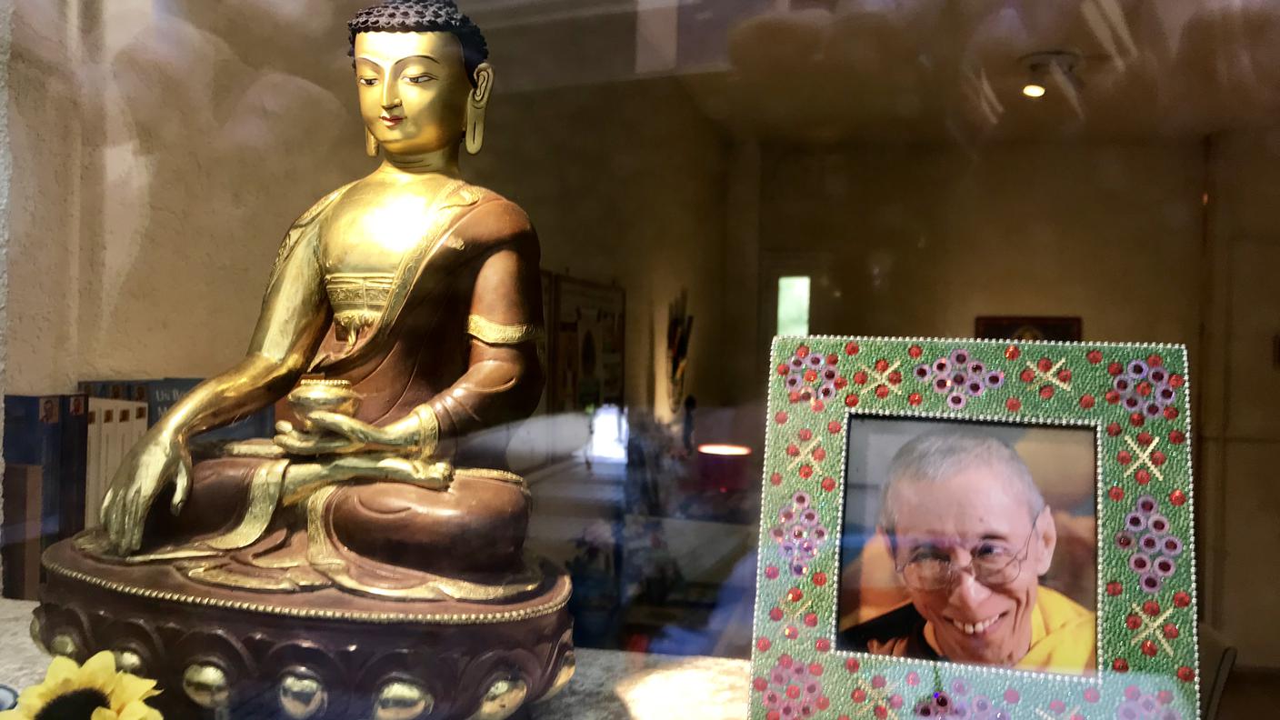 Accanto ad una statuetta raffigurante Buddha, un'immagine del maestro Geshe Kelsang Gyatso