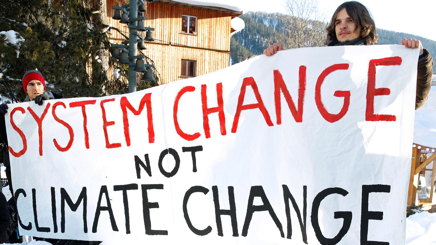 Alcuni giovani manifestanti con gli striscioni anti-WEF a Davos