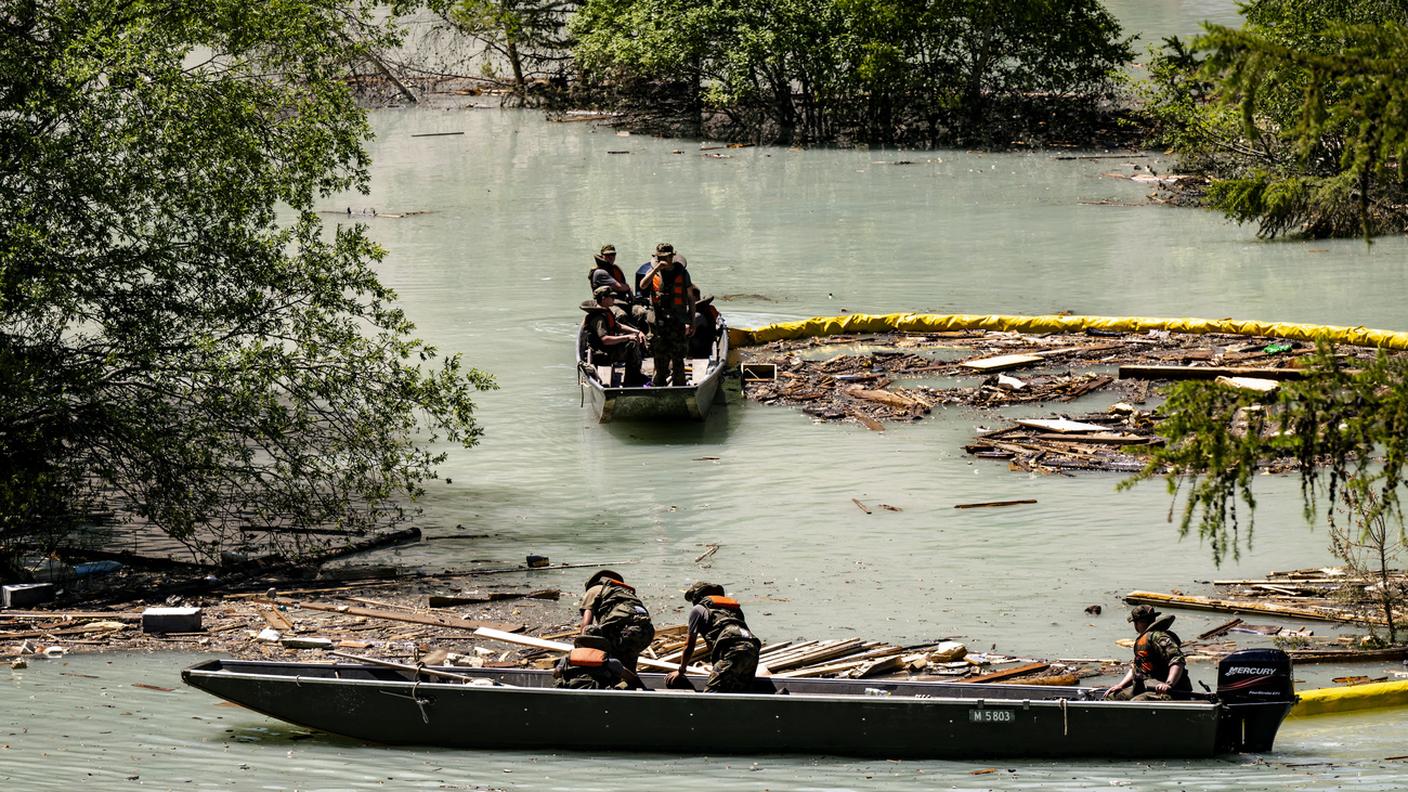 I militi mentre recuperano legname e detriti dal lago formato dalla Lonza