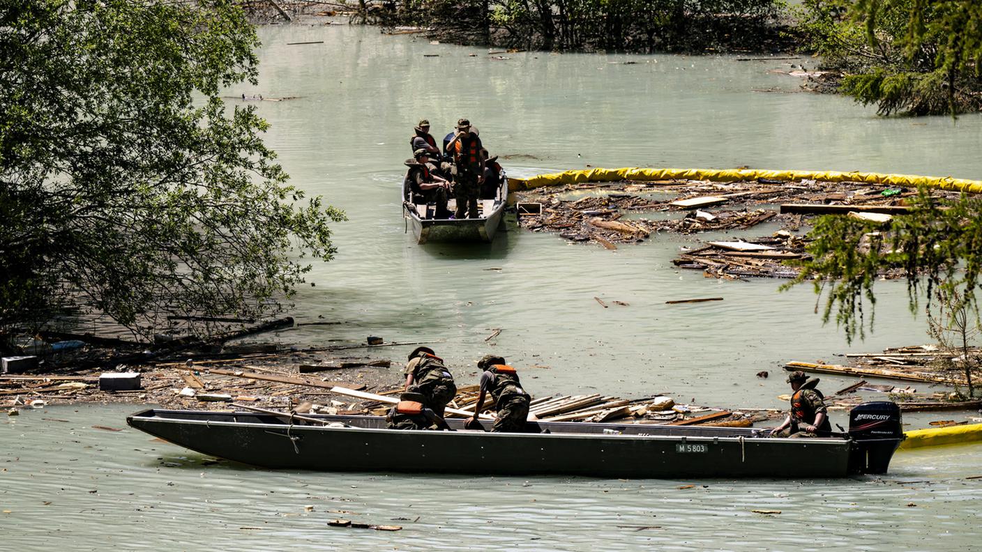 I militi mentre recuperano legname e detriti dal lago formato dalla Lonza.jpg