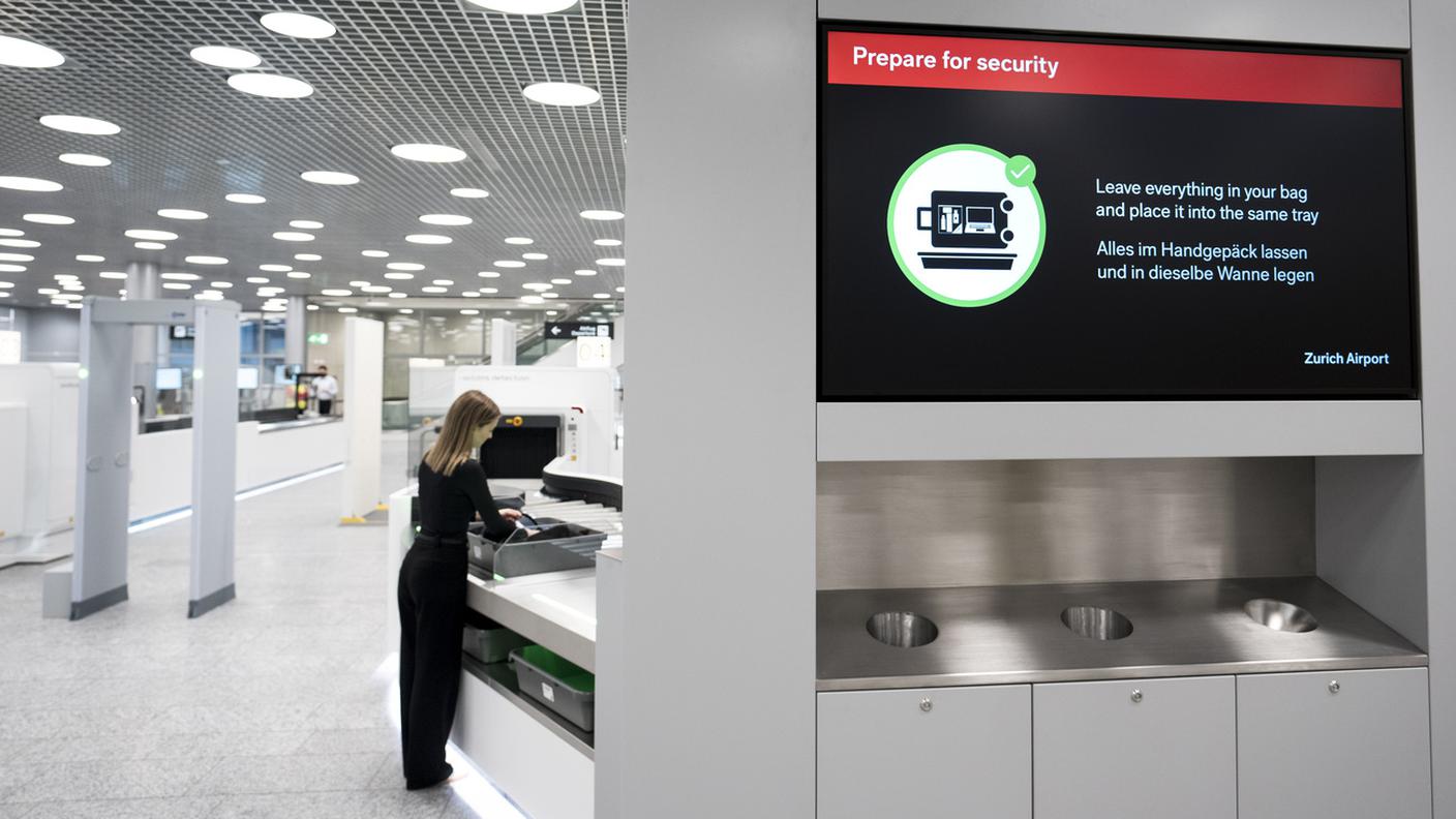 Uno schermo dell'aeroporto di Zurigo indica ai passeggeri che tutti gli oggetti possono essere lasciati nel bagaglio a mano