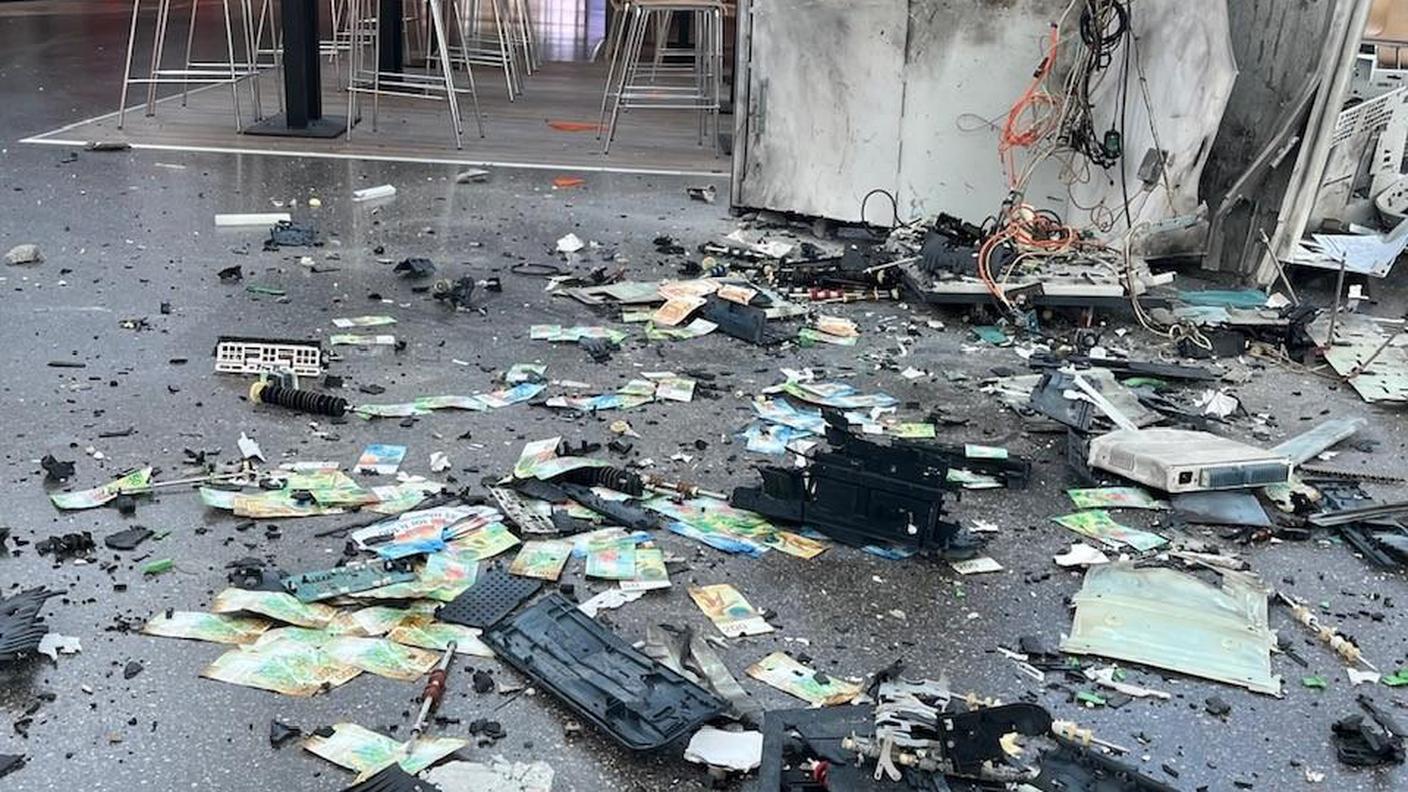 Banconote e detriti sul pavimento dopo l'esplosione di uno dei due bancomat