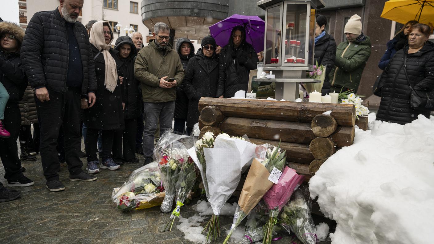 I parenti delle vittime osservano un minuto di silenzio davanti al bar "Le Constellation" a Crans-Montana