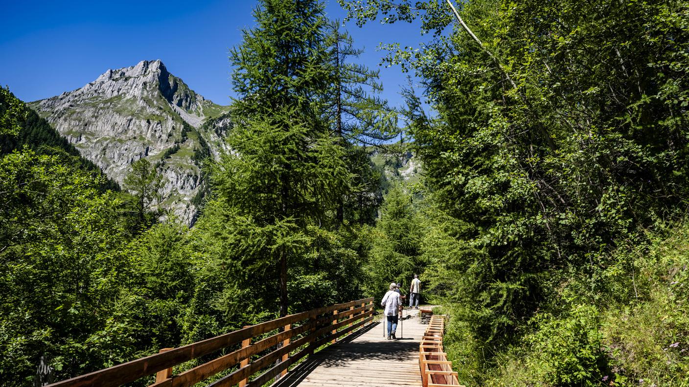 Degli escursionisti camminano lungo il Bisse du Trient, nei pressi del Col de la Forclaz, venerdì 18 luglio 2025, tra Martigny e Trient.