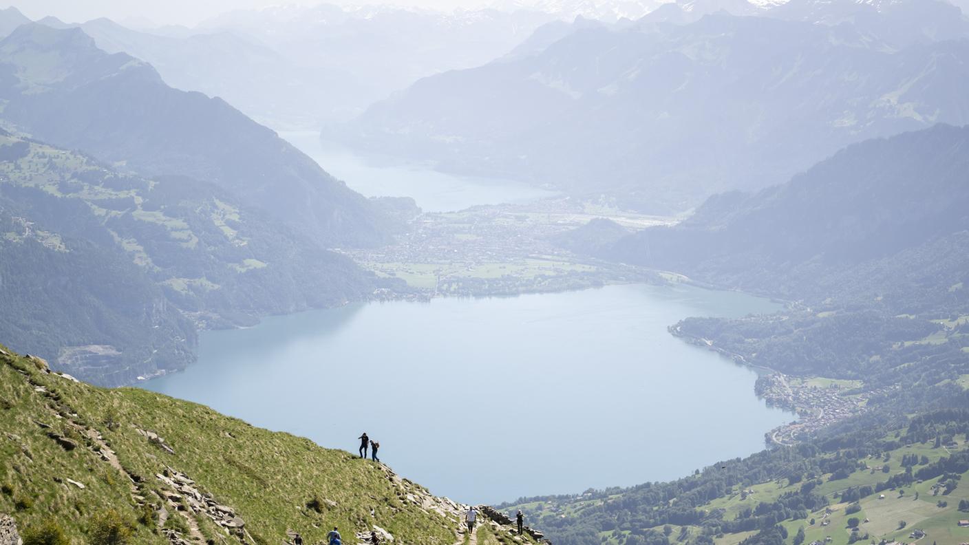 Persone percorrono il sentiero escursionistico che conduce alla vetta del Monte Niesen, con il Lago di Thun e le Alpi bernesi sullo sfondo, sopra Mülenen, in Svizzera, sabato 13 giugno 2026. 