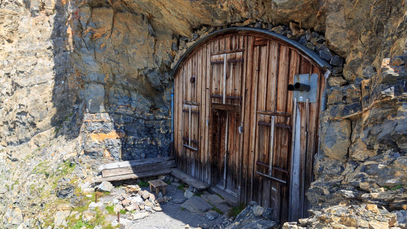 Ingresso di un bivacco fisso nelle Alpi svizzere, utilizzato come punto d’appoggio per escursionisti e alpinisti.