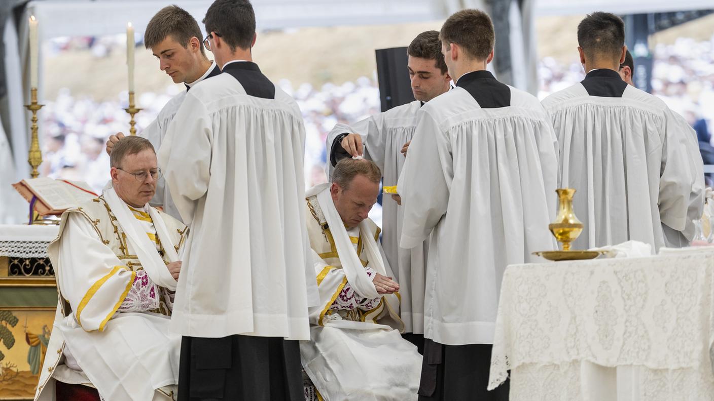 I sacerdoti Pascal Schreiber, a sinistra, e Michael Goldade ricevono la consacrazione episcopale durante la messa pontificia organizzata dalla Fraternità San Pio X, a Ecône