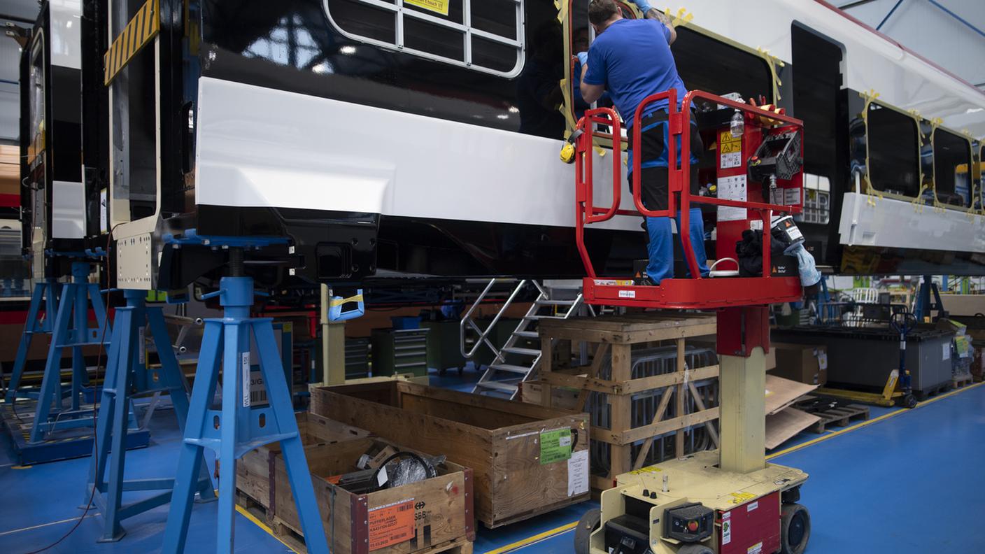 Operai della Stadler Rail impegnati nelle fasi di rifinitura di un convoglio nello stabilimento di Bussnang dove l'azienda ha la sua sede principale