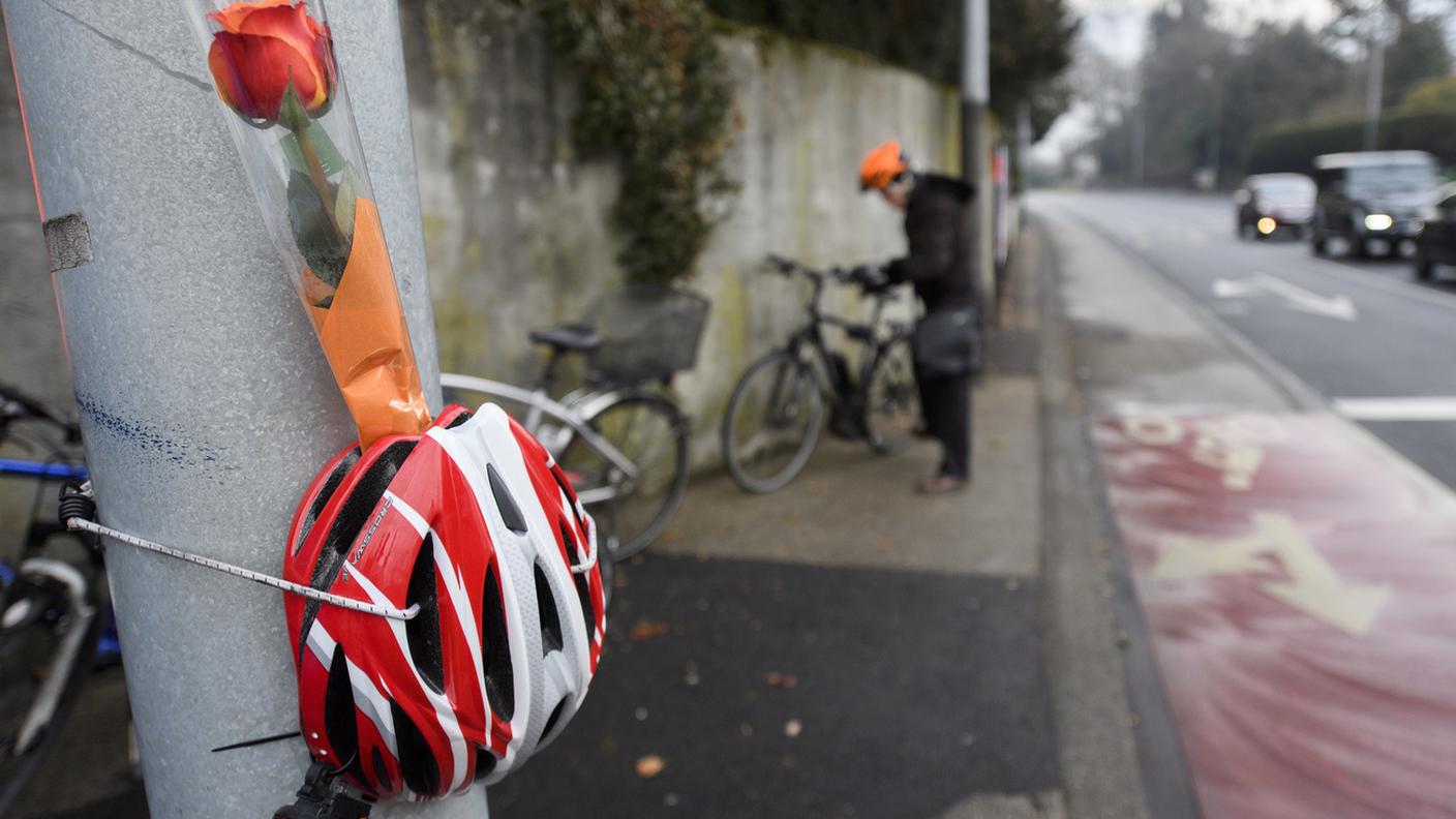 Un casco e dei fiori nel punto dove un ciclista ha perso la sua vita