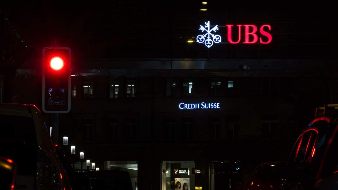 Le insegne di UBS e Credit Suisse illuminate e vicine nel centro di Zurigo, sabato