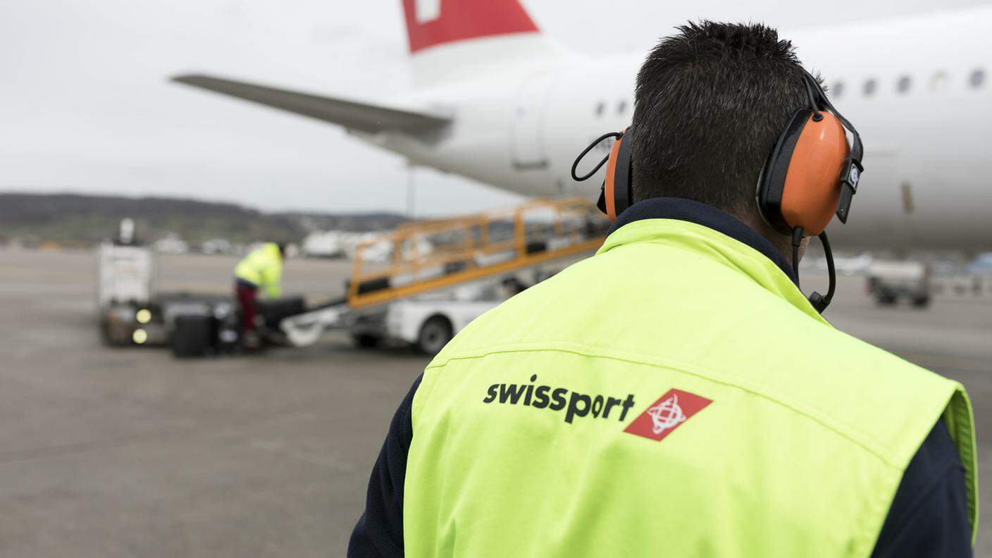 All'aeroporto di Zurigo, un supervisore svizzero di Swissport supervisiona il caricamento dell'aereo