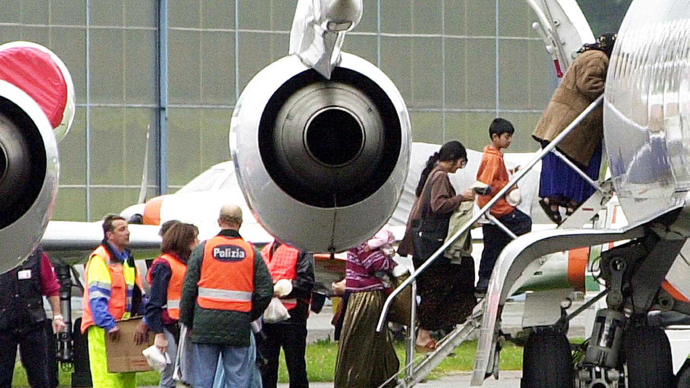 Zingari rumeni salgono sull'aereo che li riporterà in Romania