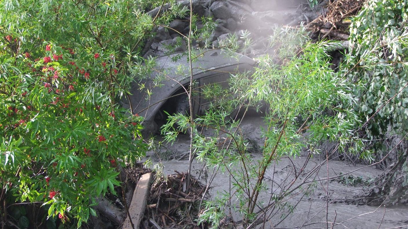 La vettura investita e sommersa da fango e detriti nel torrente Clozza