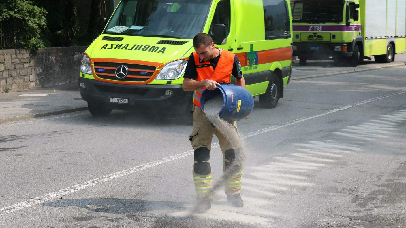 I pompieri gettano materiale assorbente sull'asfalto