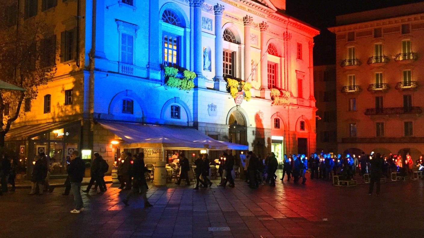 Un momento della fiaccolata con la sede del Municipio in versione tricolore