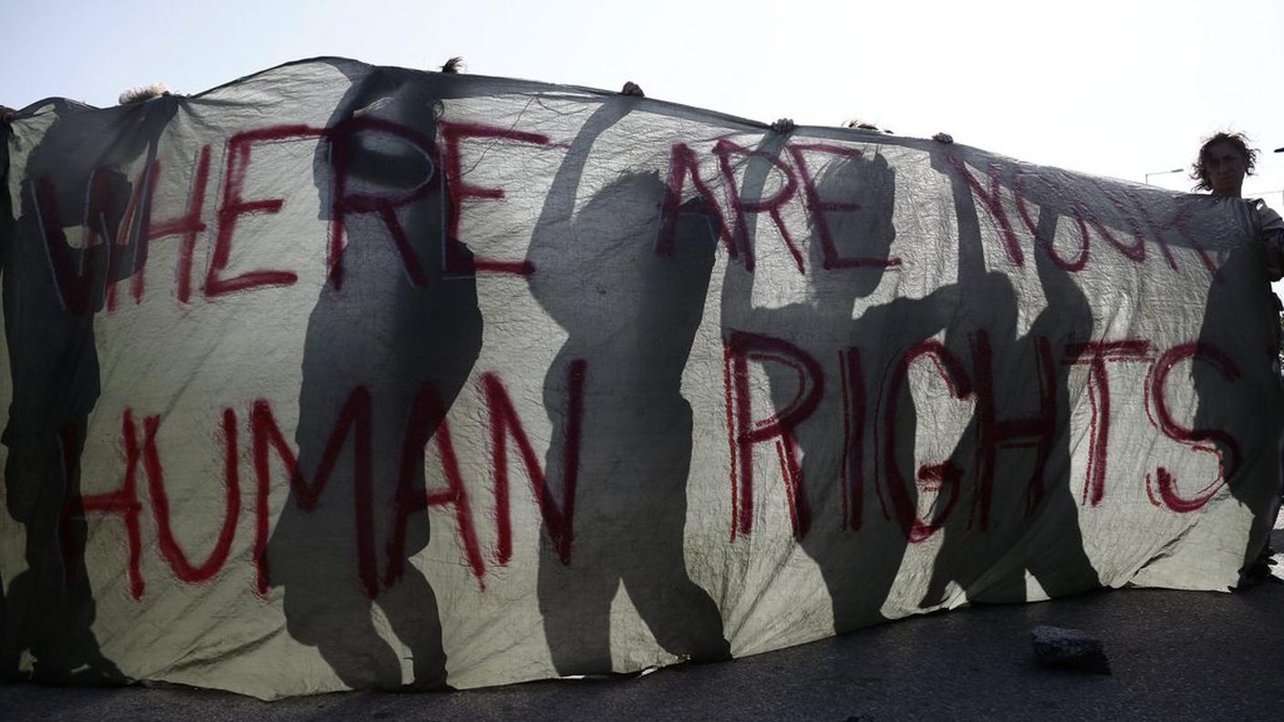 Gli striscioni portati dai volontari durante una manifestazione tenutasi fuori dal campo