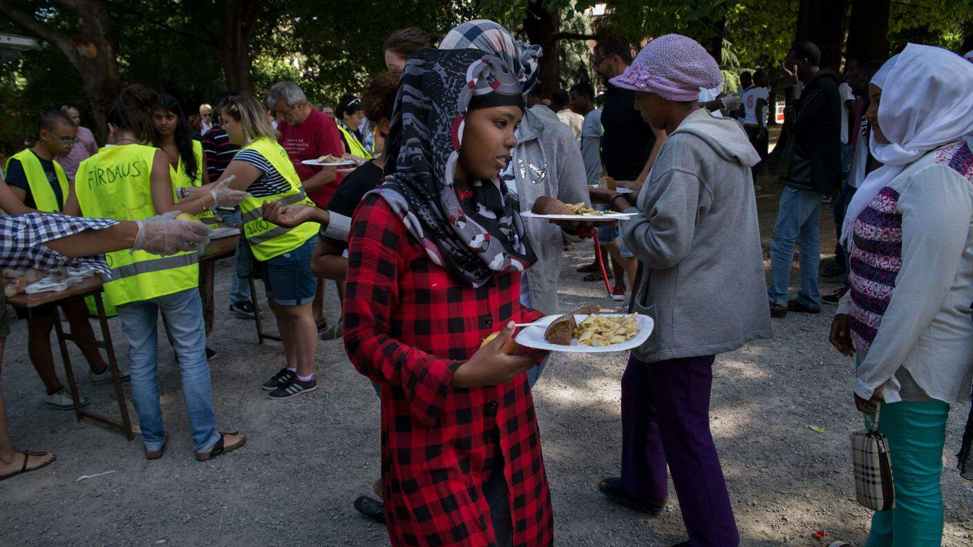 La distribuzione del pasto nel parco antistante la stazione di Como da parte dei volontari dell'associazione Firdaus