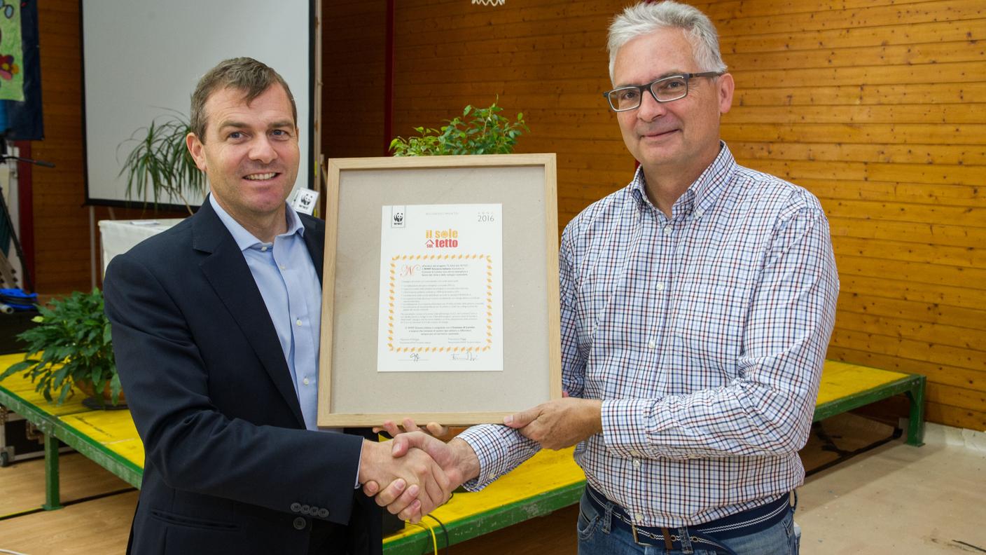 Il Sindaco di Lumino Curzio De Gottarti mentre riceve da parte di Francesco Maggi del WWF del premio "il sole sul tetto" destinto al comune di Lodrino per i suoi sforzi nelle energie rinnovabili. 