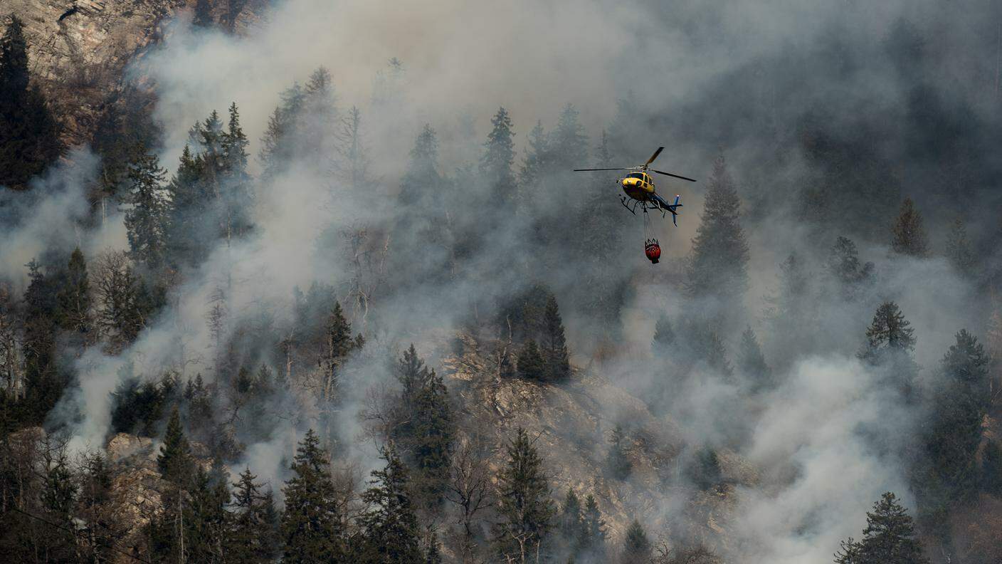 Un elicottero antincendio al lavoro sul bosco sopra Mesocco