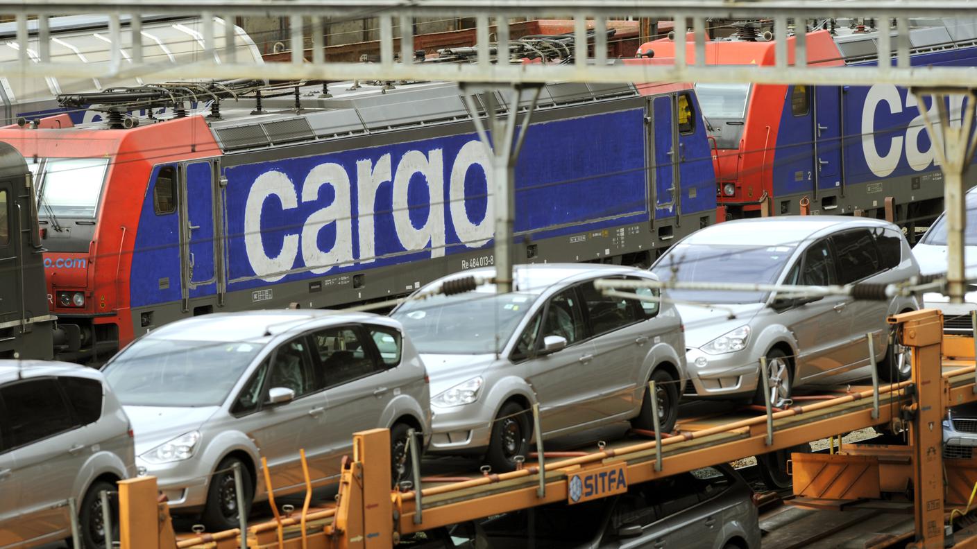 Nella foto, una locomotiva di FFSCargo e un treno carico di auto fermi in stazione a Bellinzona