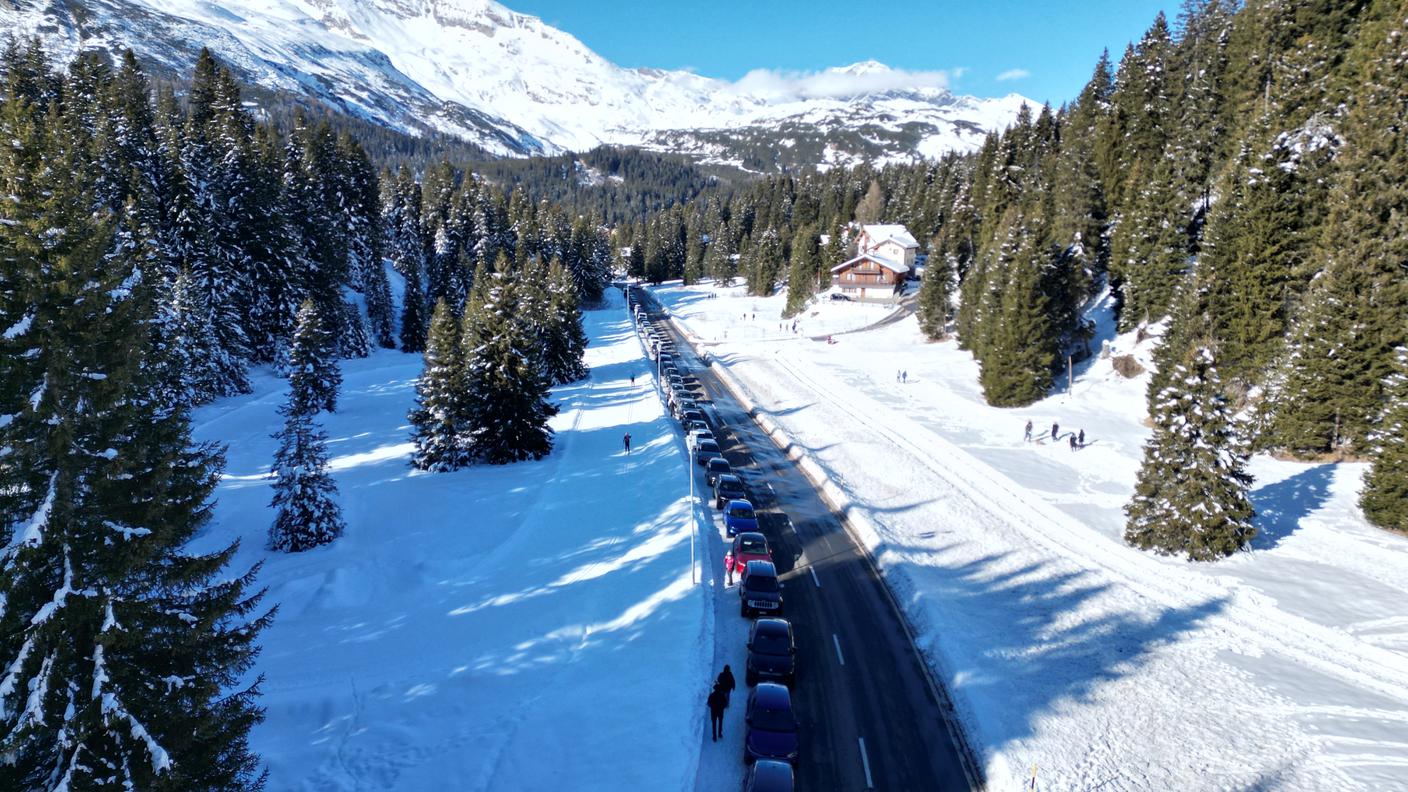 La fila di automobili posteggiate lungo la strada cantonale