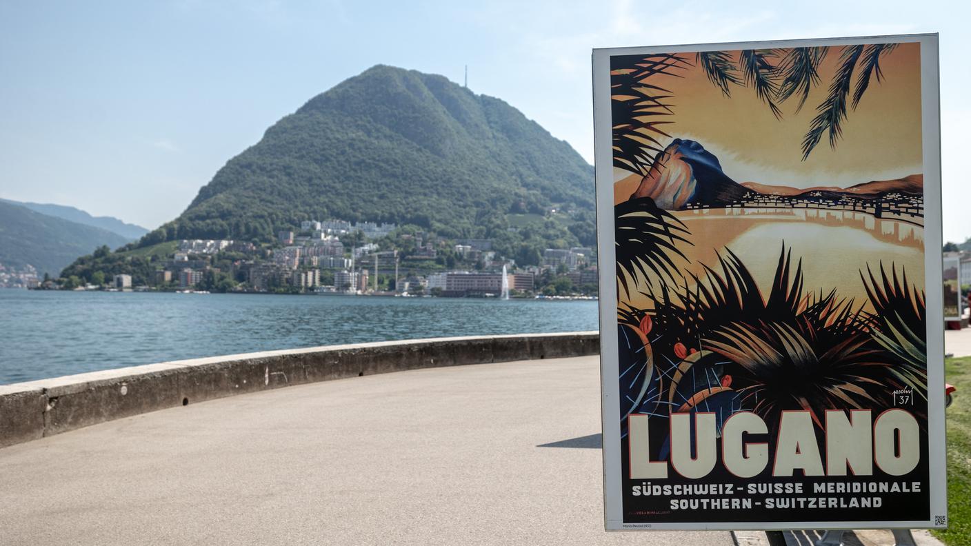 Nella foto una veduta sul lungolago Ceresio, sullo sfondo il monte San Salvatore