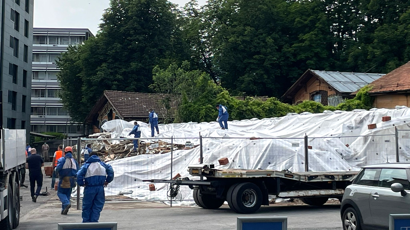 Lavoratori all'opera in tenuta di sicurezza per coprire le macerie dell'Ex Macello 