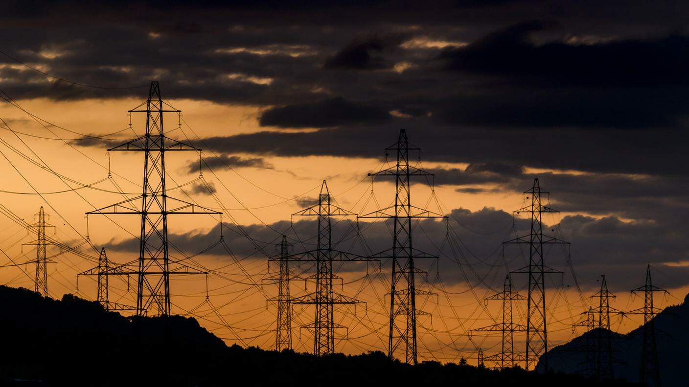 Il sole tramonta dietro i piloni della linea elettrica ad alta tensione a Collonges, nel Vallese