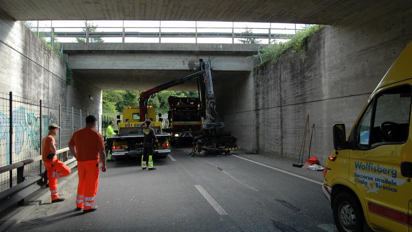 Il camion con la gru, incastrato sotto il viadotto