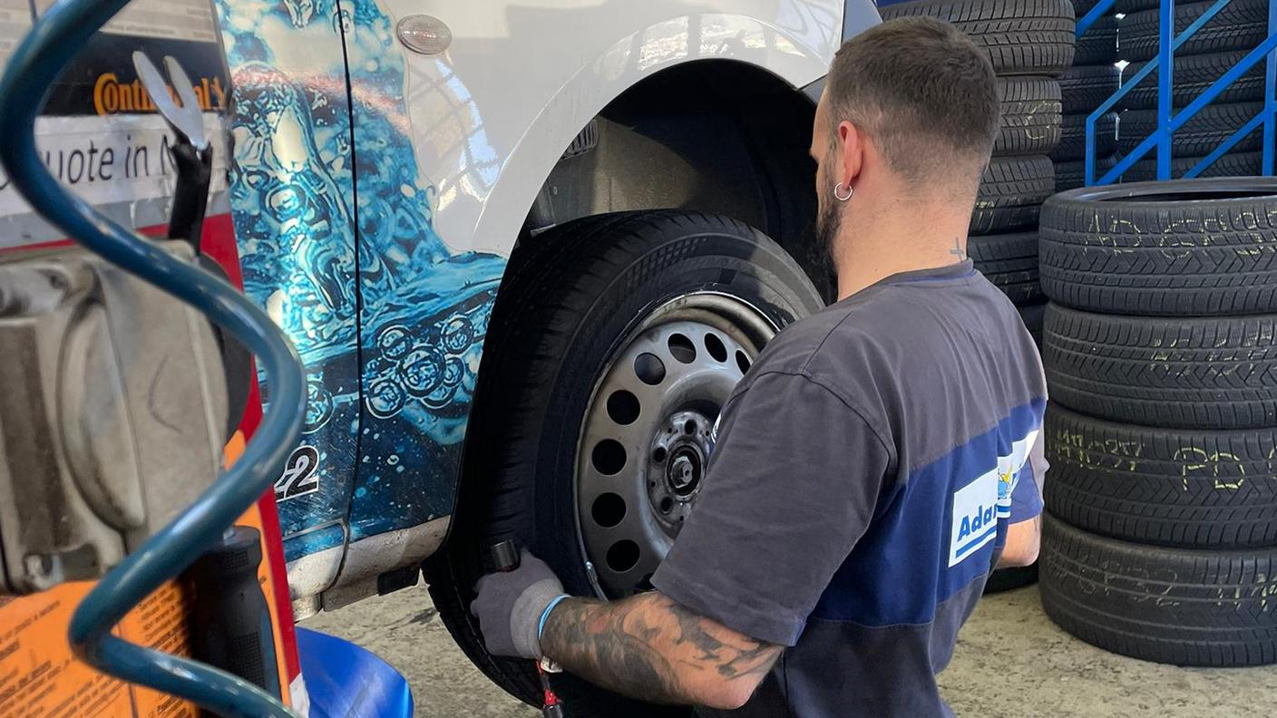 Operaio dell'Adam Touring cambia le gomme al furgone di un cliente