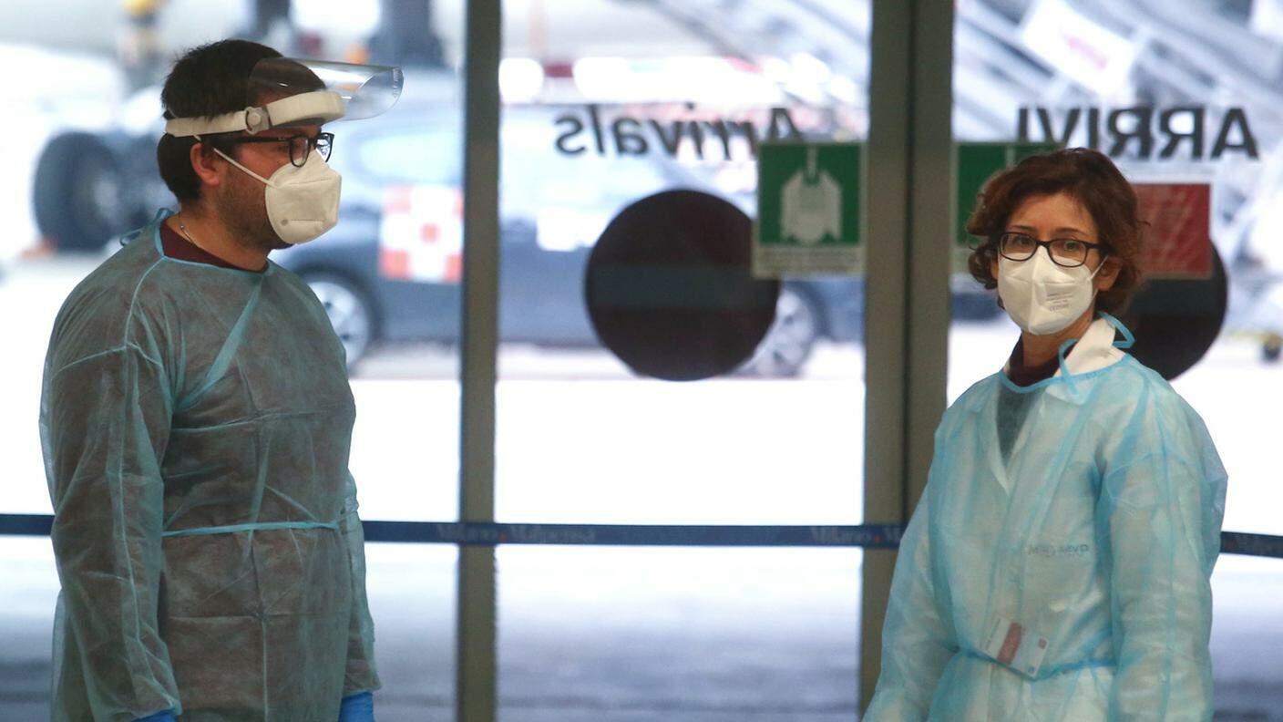 Personale sanitario in attesa di eseguire i tamponi a chi arriva in aereo dalla Cina