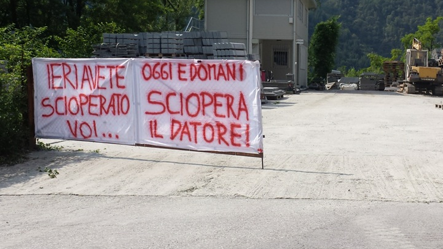 Lo striscione appeso ai cancelli di una ditta del Locarnese