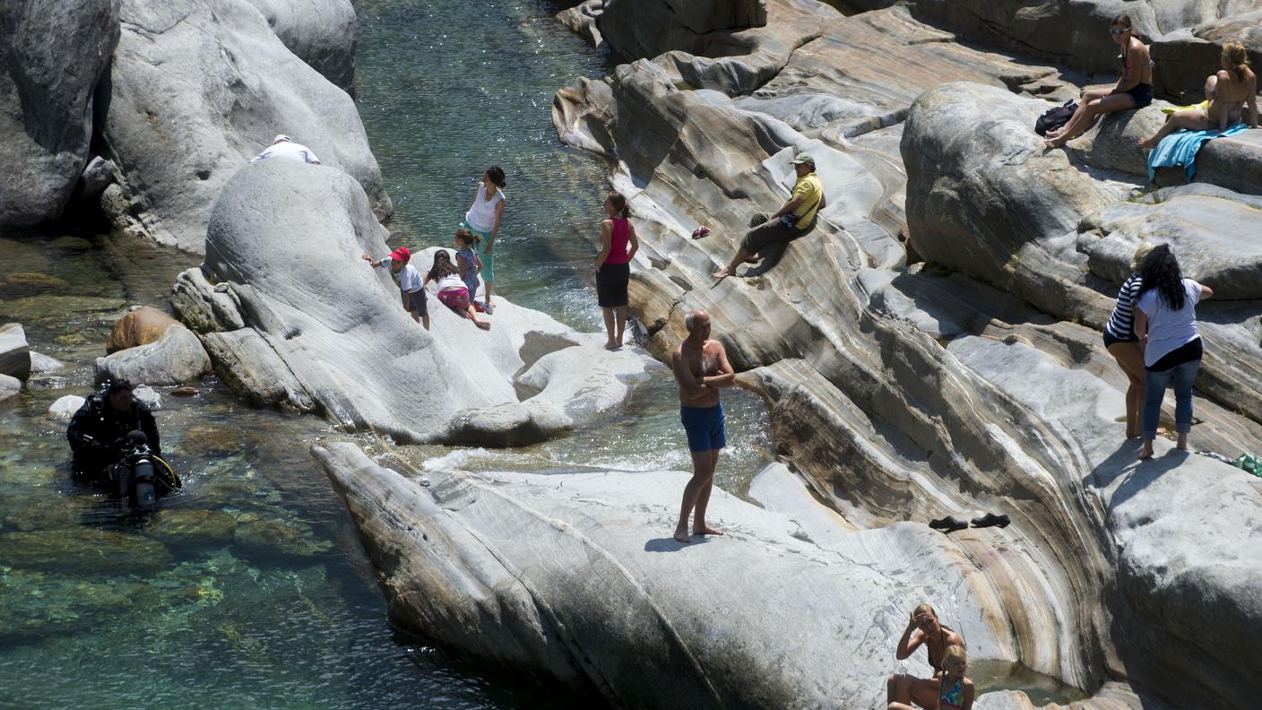 Turisti si rilassano lungo il fiume in Val Verzasca